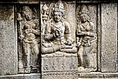 Prambanan, a male Hindu deity flanked on either sides by two female deities. These figures is probably devata and apsaras, the celestial maiden. The relief panel on the wall of Vishnu temple.
